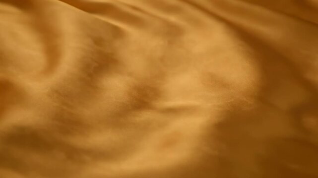 Close-up of flowing, textured golden fabric, rippling and smooth