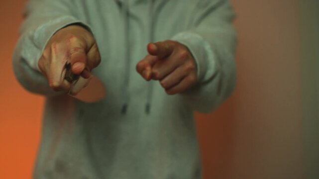A close-up of a man's hands holding a sharp kitchen knife.
Assault or domestic violence.
An aggressive man brandishes the blade of a knife at his victim.