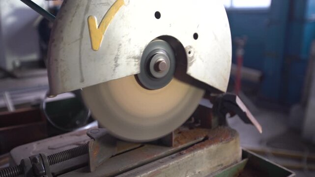 An industrial cutting disc rotates noisily at idle speed in a workshop