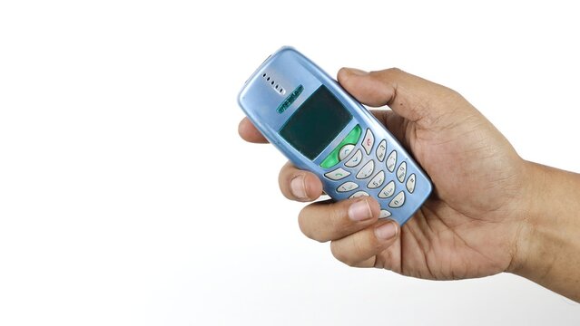Hand holding an classic mobile phone isolated on white background on April 22, 2026 in Bogor, Indonesia
