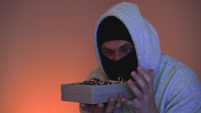 An anonymous thief guarding stolen valuables, a concept of crime and danger.
Luxury jewelry theft