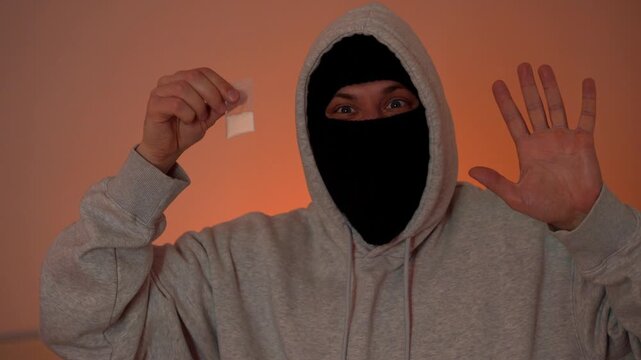 Arrest of masked suspect with drugs, police lights flashing in the background.
Drug trafficking and criminal apprehension