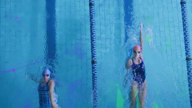 Two swimmers starting backstroke swimming side lanes making splashes and pool glow for training