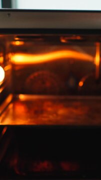 Chef placing baking tray with marinated meat into a hot oven for roasting
