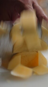 Chef slicing a fresh yellow potato on a cutting board in a professional kitchen