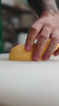Close up of chef's hands slicing potatoes with a knife on a cutting board