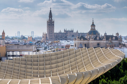 Seville, Andalusia, Spain &ndash; Feb 13, 2020: Aerial view of the modern Metropol Parasol (Las Setas) contrasting with the historic Seville Cathedral and its iconic Giralda tower in the background