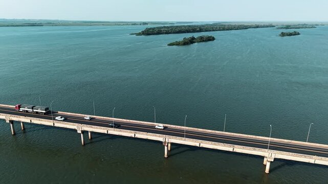 Aerial drone flyover of Ayrton Senna Bridge over Paran&aacute; River, connecting Gua&iacute;ra and Mundo Novo, Brazil, with vehicles moving along a long highway bridge.