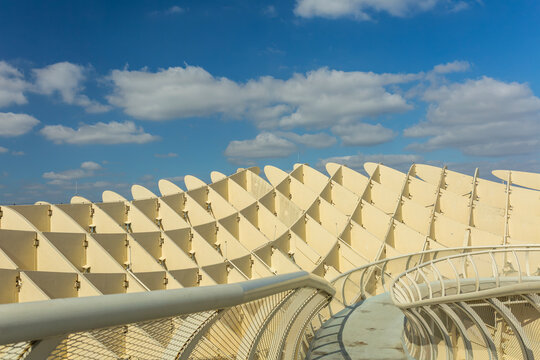 Seville, Andalusia, Spain &ndash; Feb 13, 2020: Close-up of Metropol Parasol, also known as Las Setas de Sevilla, showcasing its unique wooden structure, geometric patterns, and curved walkway against a vib