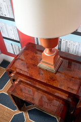 Dramatic orange lamp on a burl side table stack © Alene Photographs