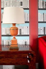 Dramatic orange lamp on a burl side table stack © Alene Photographs