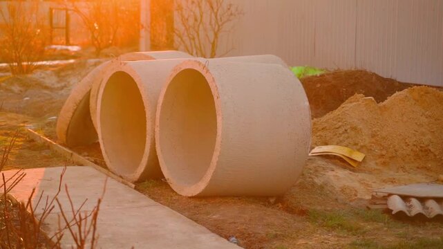 Concrete construction rings lying at building site at sunrise