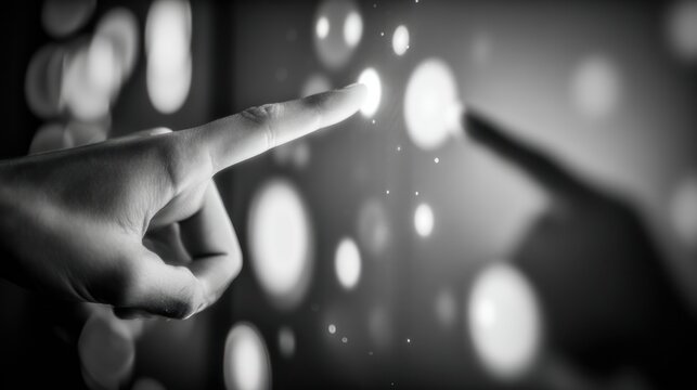 Human hand pointing towards glowing digital sphere concept in monochrome