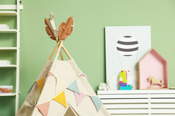 Cute wigwam with garland in stylish child's room, closeup. Space for text © New Africa