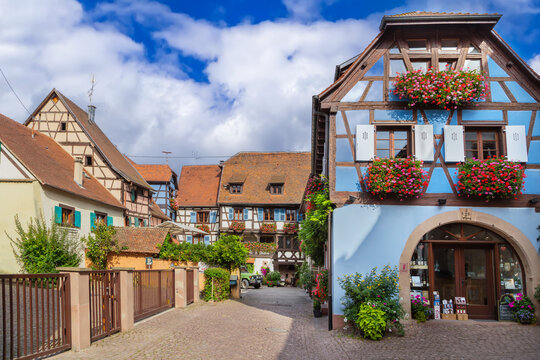 Picturesque historic street in Eguisheim Alsace France. Traditional half timbered architecture and facade under cloudy sky