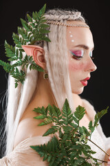 Naklejka premium Beautiful elf girl with floral decor on black background