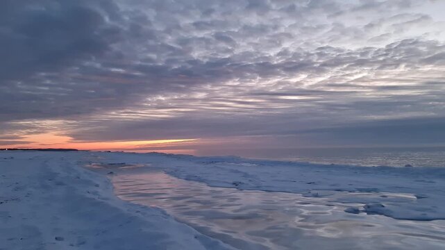 Winter in Lettland, die Baltic Sea, Eis, Schnee, Himmel, die Sonne hinter den Wolken f&auml;rbt den Horizont, Schnee auf dem Sand, Meeresk&uuml;ste, Stadt Ventspils