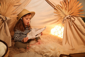 Little girl with drawing of map near wigwam at home. Space for text © New Africa