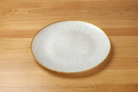 Empty white plate on wooden table