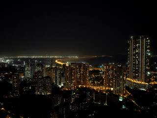 Obraz premium India's Longest Sea Bridge: Trans-Harbour Sea Link. Atal Setu sea bridge in Mumbai, Maharashtra, India. A city at night with bright skyscrapers and a dense network of glowing buildings.