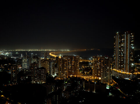 India's Longest Sea Bridge: Trans-Harbour Sea Link. Atal Setu sea bridge in Mumbai, Maharashtra, India. A city at night with bright skyscrapers and a dense network of glowing buildings.
