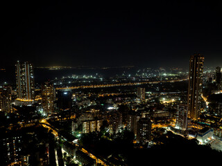 Fototapeta premium Cinematic view of Mumbai city at night. Mumbai's iconic financial district with this stunning cityscape view. Shot of Mumbai Skyline, high-rise buildings at South Mumbai, Maharashtra India.