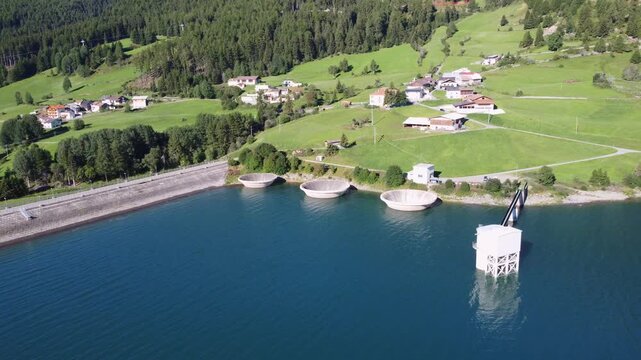 Aerial drone view of Resia Lake dam: sustainable hydroelectric power infrastructure, Renewable energy production, and environmental engineering in the Italian Alps landscape