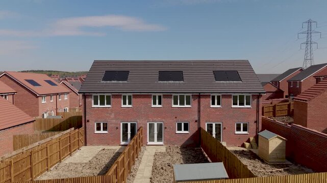Aerial drone footage of brand new homes with solar panels and heat pumps on a UK construction site
