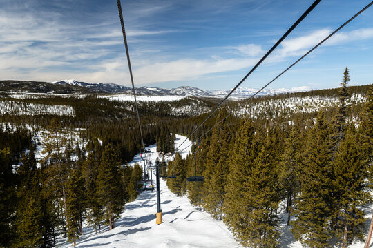 Riding up a chairlift overlooking the Rocky Mountains in winter