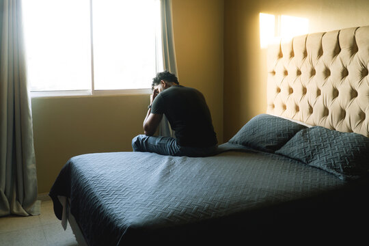 Man feeling distress in bedroom contemplating mental health