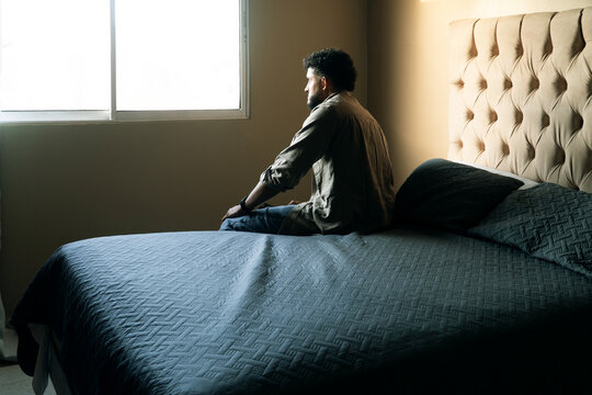 Man experiencing sadness looking out window