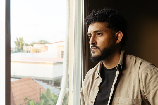Man contemplating life through home window