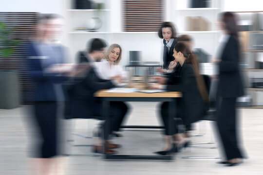Colleagues working indoors, motion blur effect. Hustle and bustle office life