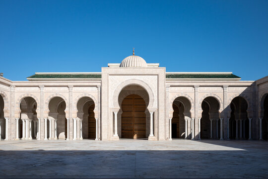 TUNIS, TUNISIA - APRIL 10, 2026: The main entrance and arched facade of the Malik ibn Anas Mosque under a clear blue sky in Carthage.