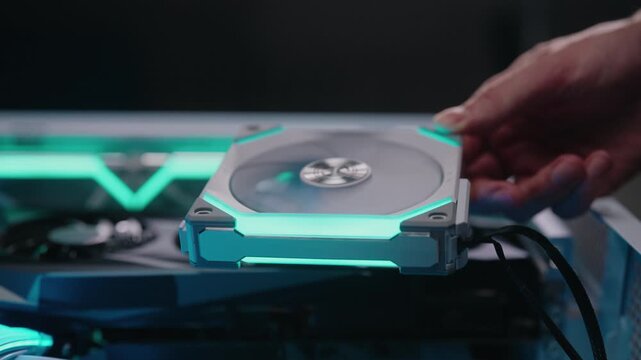 Skilled technician installing modern rgb cooling fan into custom gaming computer case for optimal performance, maintenance, thermal management during system upgrade, close-up, slow motion.