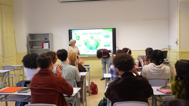 University students applauding a classmate after a successful presentation about environmental issues and ecology in a modern classroom