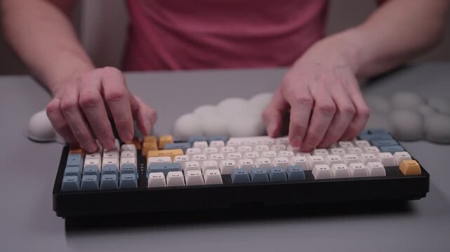 Male hands typing on modern mechanical keyboard with comfortable ergonomic wrist rest, promoting correct posture and preventing repetitive strain injury at office desk, close-up, slow motion.