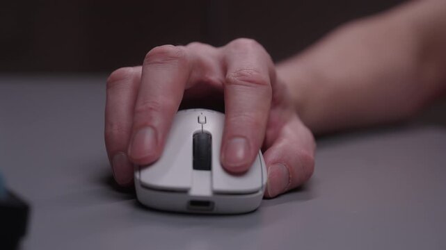 Close-up of person hand using wireless computer mouse on desk mat, then placing ergonomic wrist rest behind to prevent carpal tunnel syndrome and reduce strain. Shooting in slow motion.