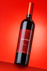 Fototapeta premium Red wine bottle mockup on red background
