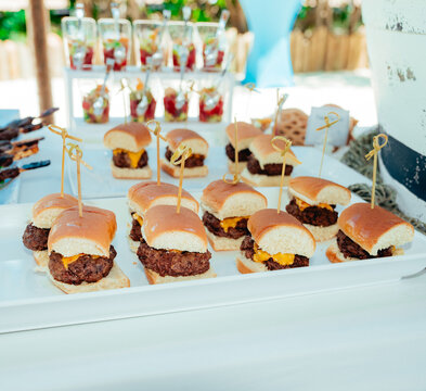 Mini cheeseburger sliders served on catering tray at outdoor event