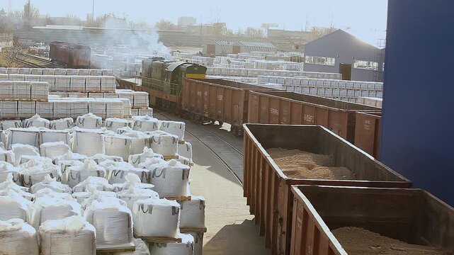 Industrial logistics zone at a large plant or transshipment hub. Industrial logistics. A freight car moves through a factory warehouse. Industrial rail freight transportation. Outdoor storage. 