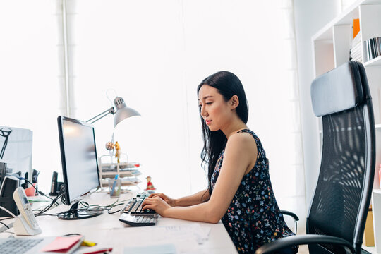 Focused woman working at computer in bright office