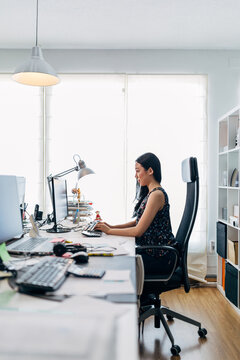 Young woman working at computer in bright home office