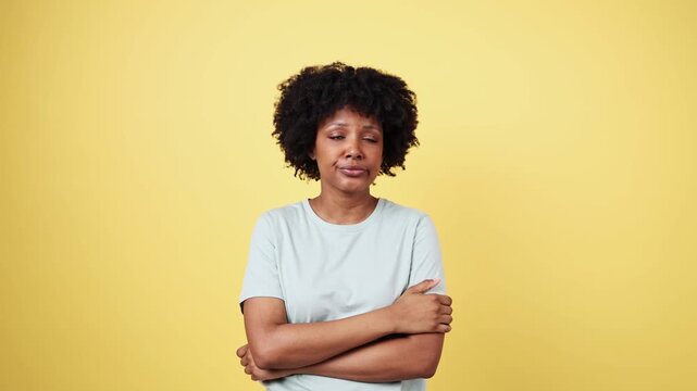 Sleepy young woman yawning and stretching on yellow background