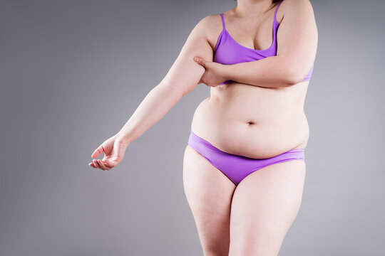 Overweight woman pinching armpit fat, weight loss and hand liposuction