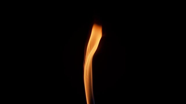 Slow motion close-up of a slender flame flickering and bending gracefully on a black background, showcasing elegant fluid motion and warm glowing shades of orange and gold