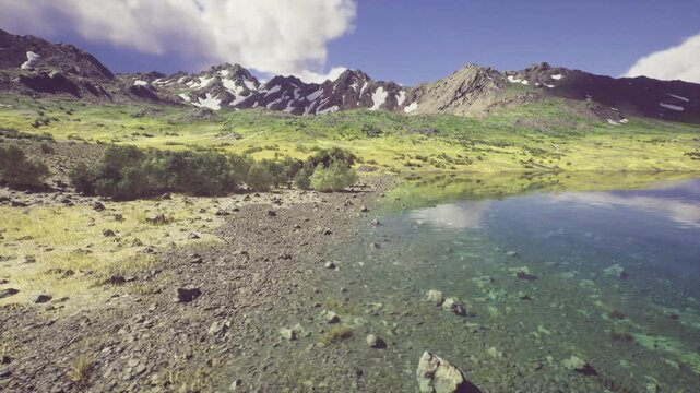 alpine lake with glassy peak reflection clear turquoise water, rocky shore, wildflower meadow, distant snowcaps, soft morning light, cloud shadows on slopes,