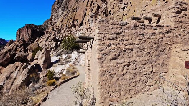 Scenic view of ancient settlements carved into rock cliffs at Bandelier National Monument in New Mexico