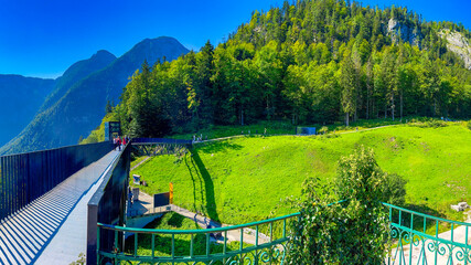 Fototapeta premium Hallstatt, Austria - September 2nd, 2021: Picturesque view of Hallstatt city with tourists, nestled by the serene lake and surrounded by majestic mountains