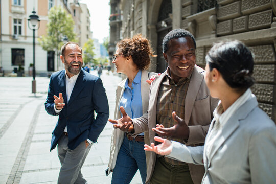 Diverse business colleagues chatting on city street